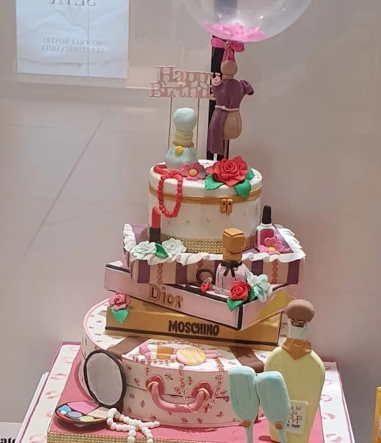 Torta con decorazioni rappresentanti di oggetti di moda