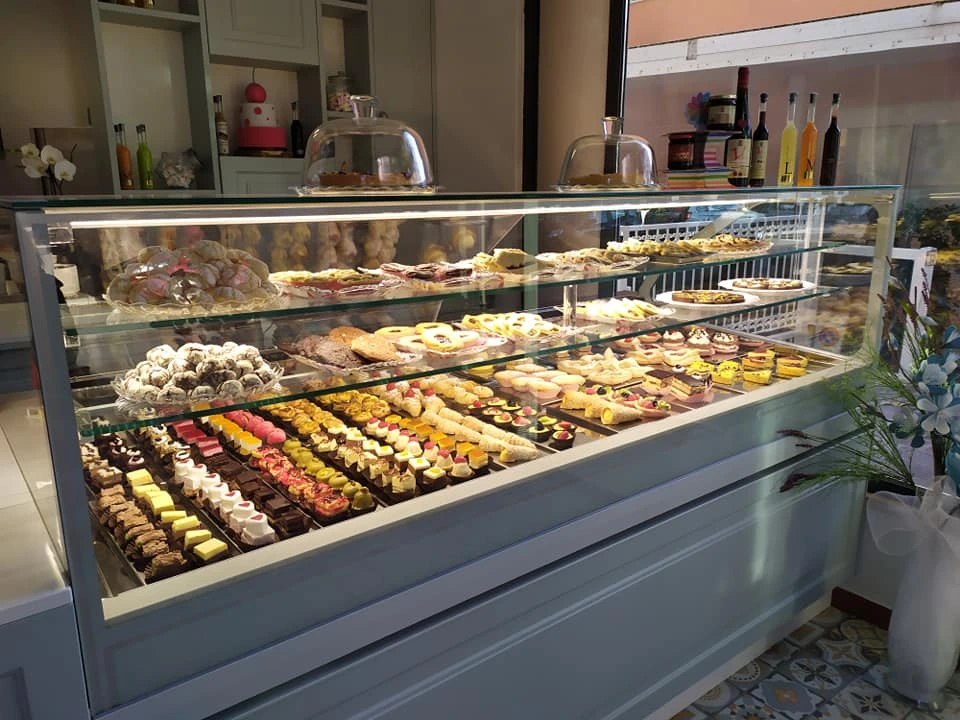 Foto della vetrina della pasticceria piena di mignon